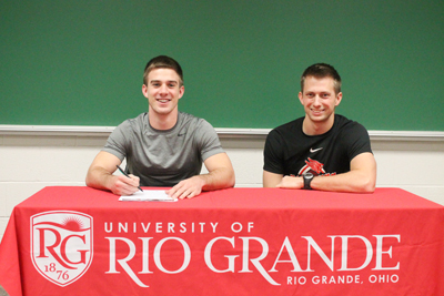 Former Gallia Academy standout Brett Wilson poses with Rio assistant coach Steve Gruenberg after signing with the RedStorm